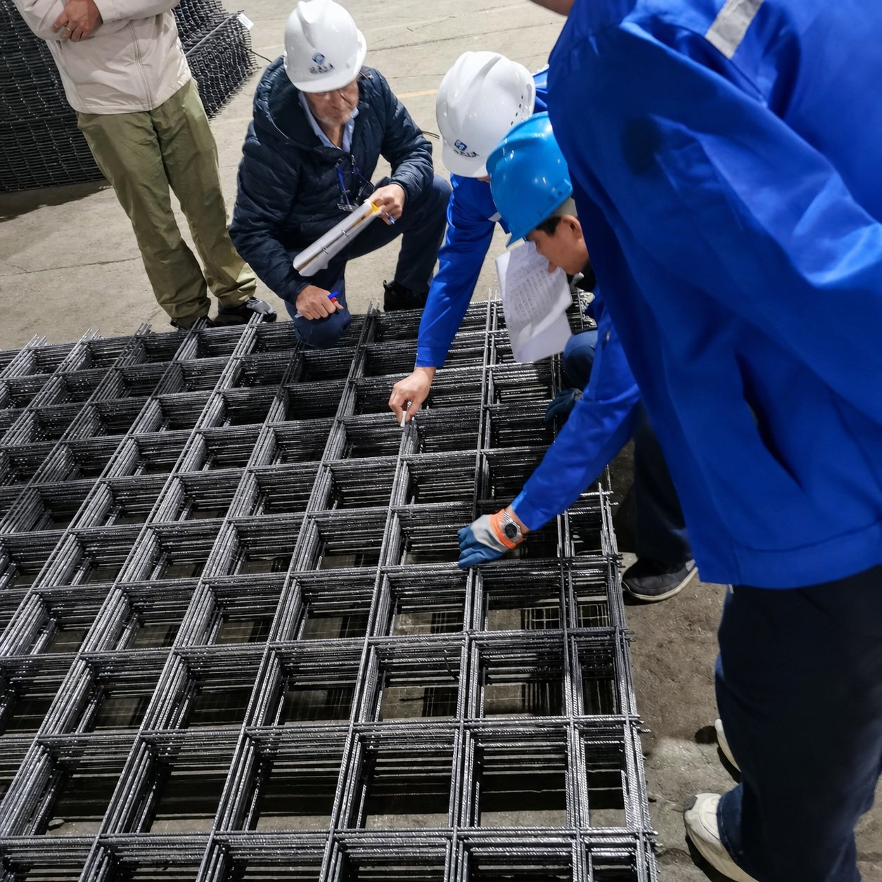 Team inspecting reinforcing mesh sheets